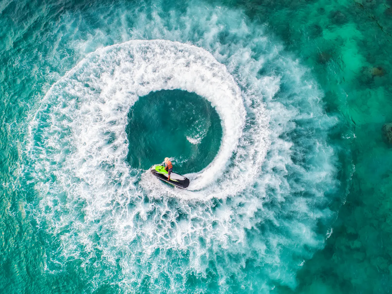 Aerial view of a jet ski carving a spiral wake on Lake Norman